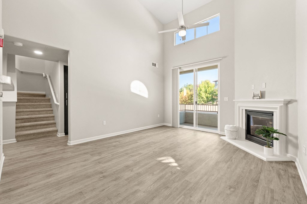 an empty living room with a fireplace and a staircase