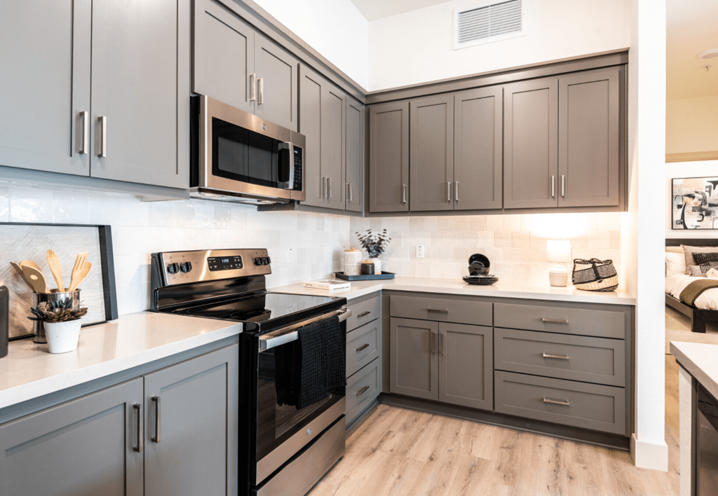Lathrop Apartments for Rent - Towne Centre - Modern Kitchen with Grey Cabinets, White Countertops, and Stainless Steel Appliances