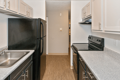 a kitchen with black appliances and white cabinets