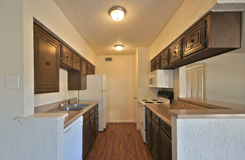 The Evergreens kitchen area with white appliances and dark cabinetry - Photo Gallery 6