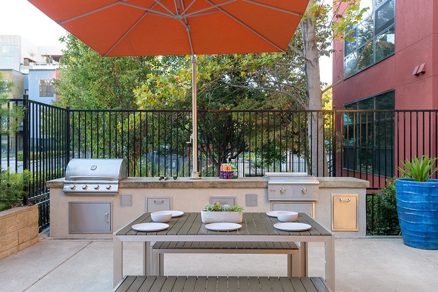utside Grills With a Large Umbrella, Seating, and Tables at FREMONT MEWS, California, 95814
