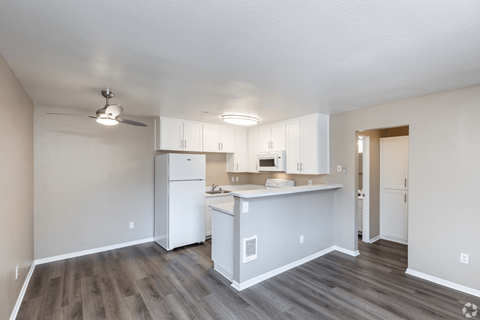 A kitchen with white cabinets and a white refrigerator.