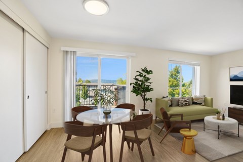 A dining room with a table set for two and a view of the balcony.