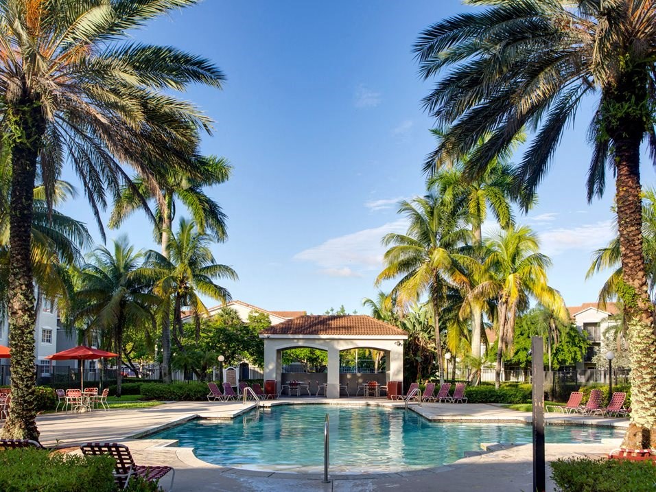 Pool with lounge chairs at Banyan Pointe, Coconut Creek, FL 33073