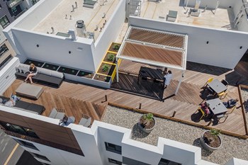 Dog-Friendly Apartments in Oakland CA - Electric Lofts - Outdoor Seating Areas, Planted Shrubs, and Wood Flooring - Photo Gallery 2