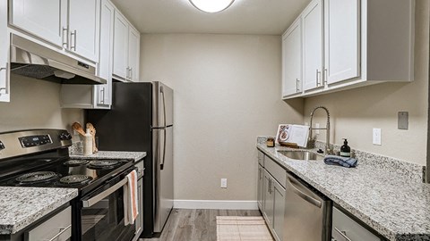 an updated kitchen with granite counter tops and stainless steel appliances