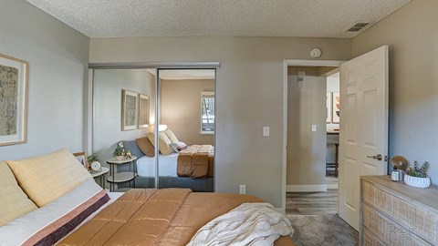 Apartments in Hayward for Rent - Austin Commons - Bedroom with Mirrored Closet, Bed, and Dresser.