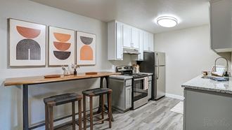 Apartments for Rent in Hayward, CA - Austin Commons - Kitchen with White Modern Cabinets, Stainless-Steel Appliances, and Granite-Style Countertops