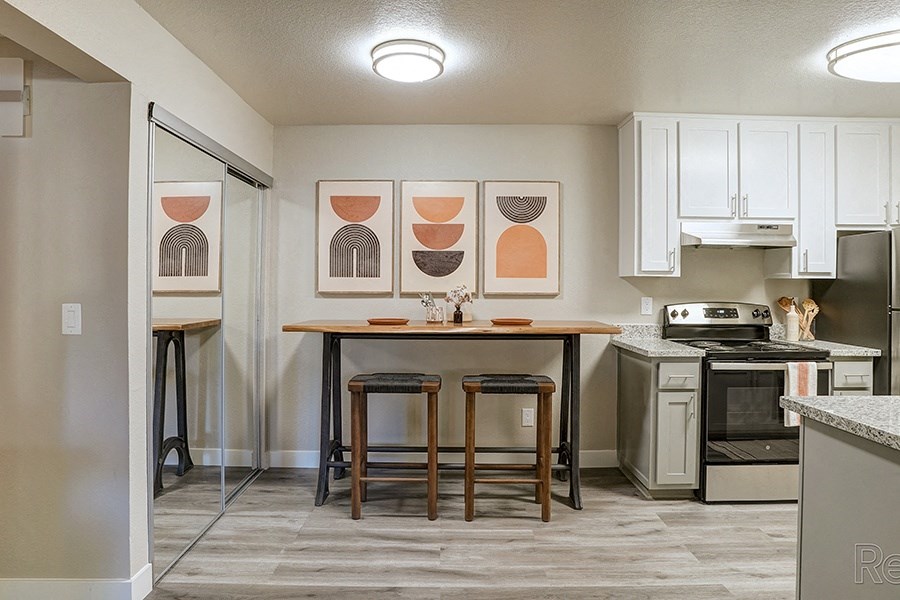 Hayward, CA Apartments - Austin Commons - Dining Area with Long Dining Table, Wooden Stools, and Table Decor
