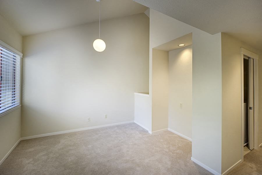 a large empty room with a pendant light hanging from the ceiling