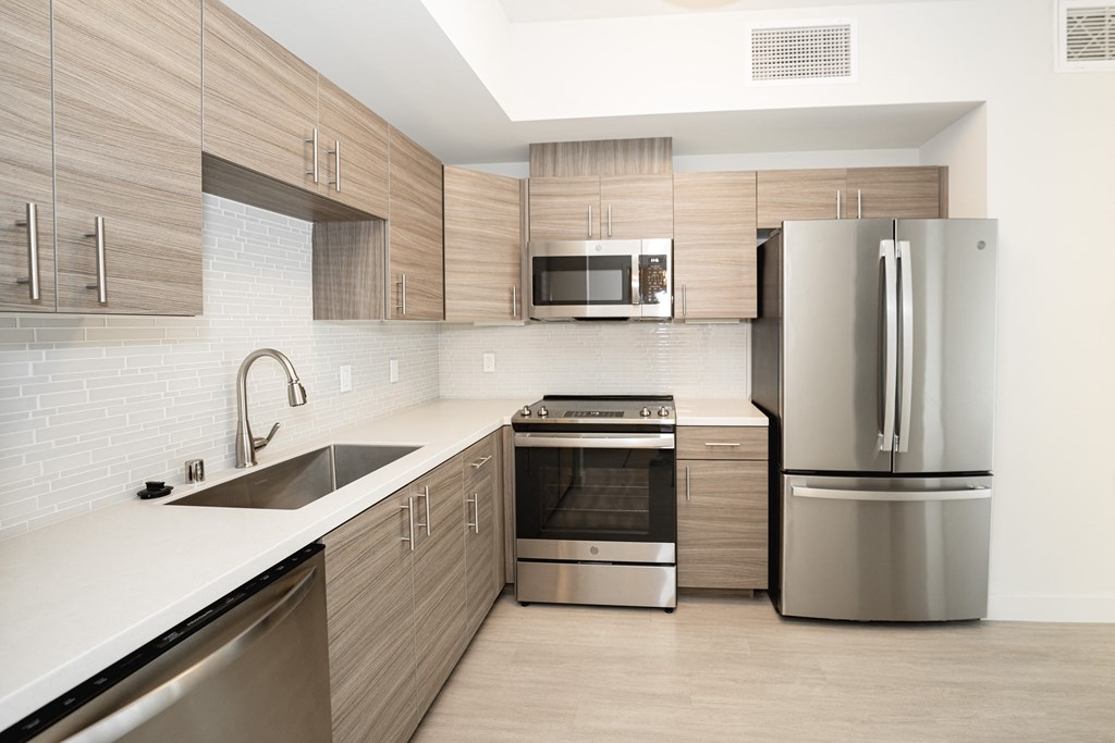 a modern kitchen with stainless steel appliances and wooden cabinets