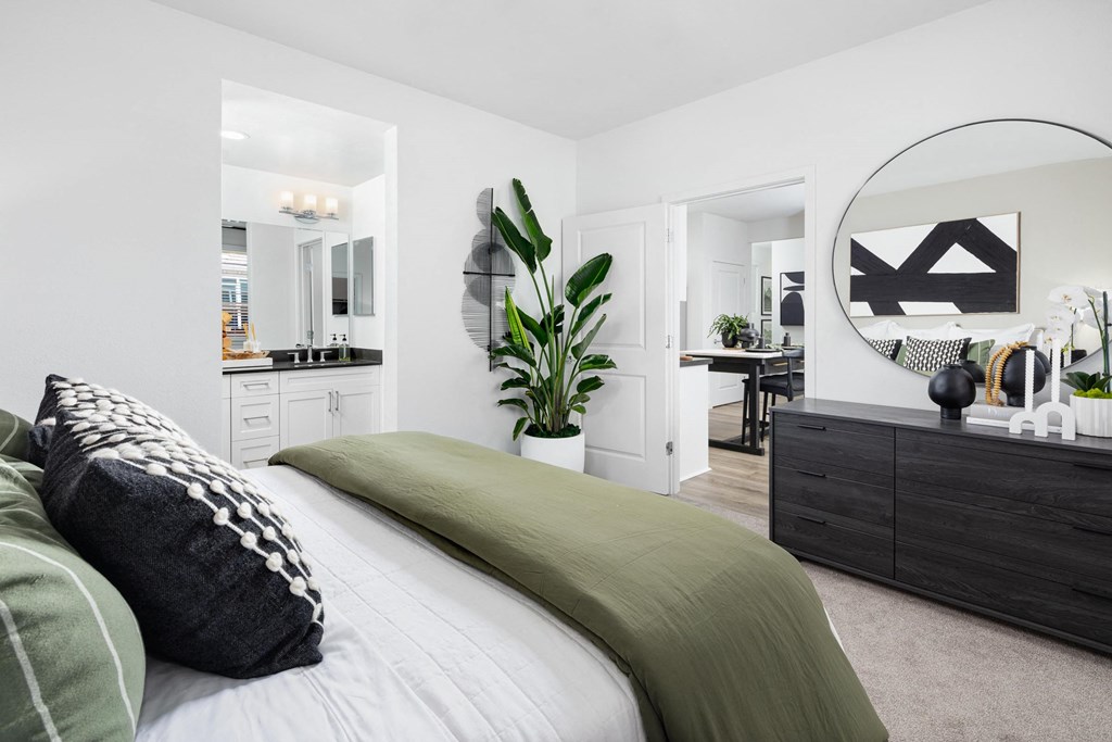 a bedroom with white walls and a green bedspread