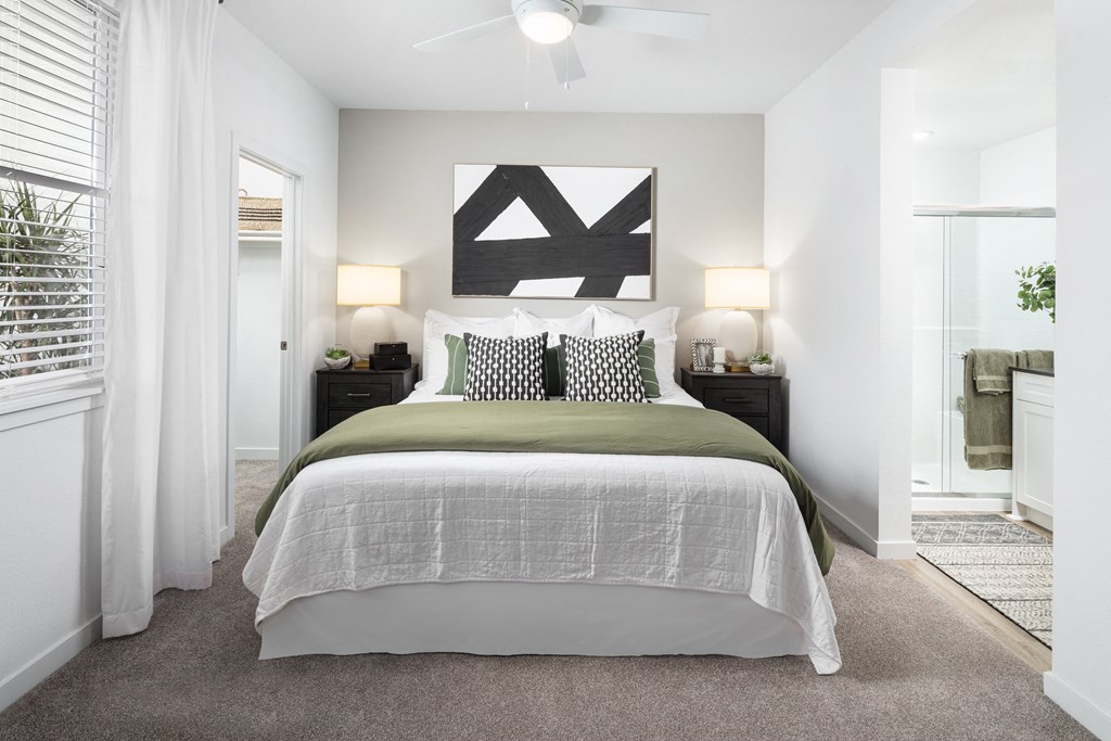 Two-Bedroom Apartments in Roseville, CA - Solstice at Fiddyment - Bedroom with Plush White Bedding,  Double Nightstands, and Bathroom Access