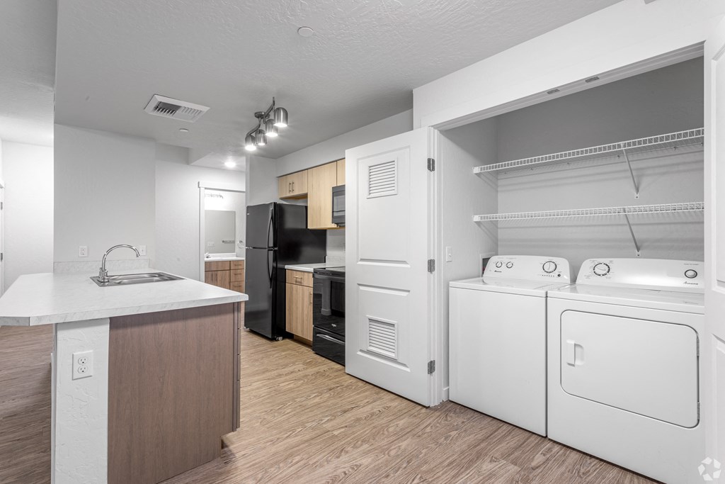 a renovated kitchen with a washer and dryer and a counter with a sink