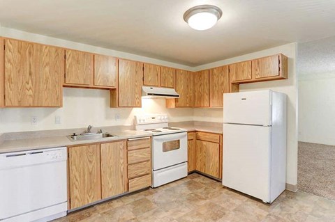 A kitchen with wooden cabinets and white appliances.