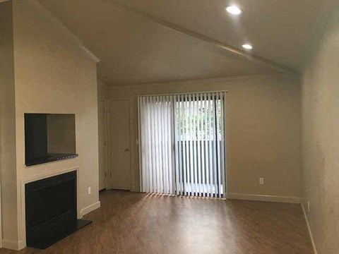 a living room with a fireplace and a sliding glass door