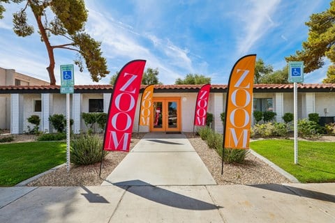 The image shows a building with a sign that reads "ZOOM" in front of it.