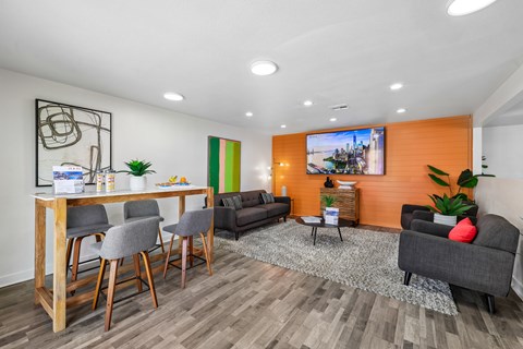 A modern living room with a dining table and grey chairs.