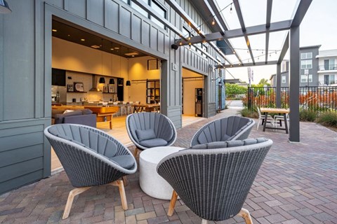 a patio with chairs and a kitchen in a building