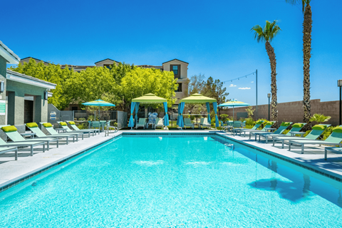 A large swimming pool with lounge chairs and umbrellas.