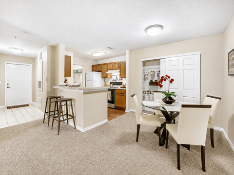 A kitchen with a dining table and chairs.