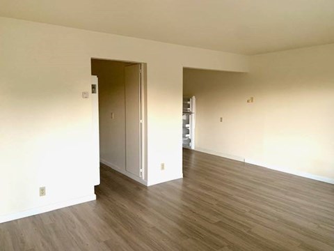 A room with a wooden floor and a doorway leading to another room.at OTAVON APARTMENTS, Novato, 94947
