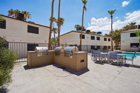 Outdoor grilling stations with dining area by pool at Dash Apartments, Nevada