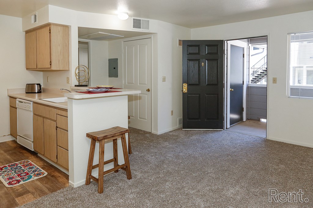 a kitchen and living room with an open door to a hallway