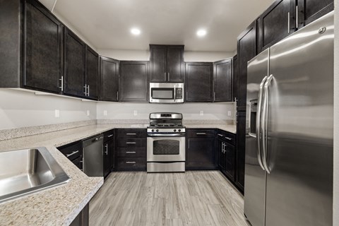 a kitchen with stainless steel appliances and black cabinets