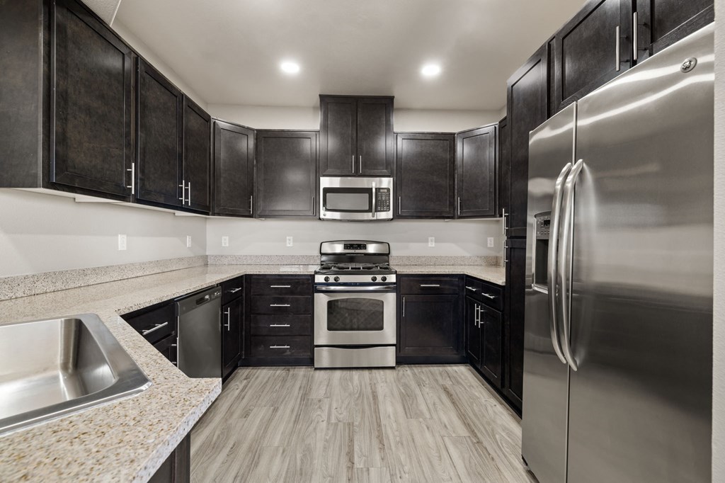 a kitchen with stainless steel appliances and black cabinets