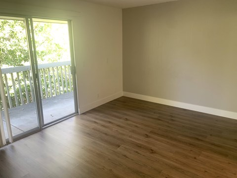 A room with wooden flooring and a sliding glass door.at OTAVON APARTMENTS, Novato, 94947