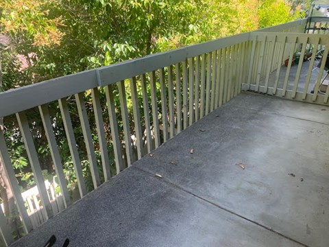A concrete balcony with a white railing.at OTAVON APARTMENTS, California