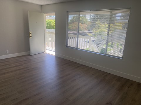 A room with a white door and a window with blinds.at OTAVON APARTMENTS, Novato California