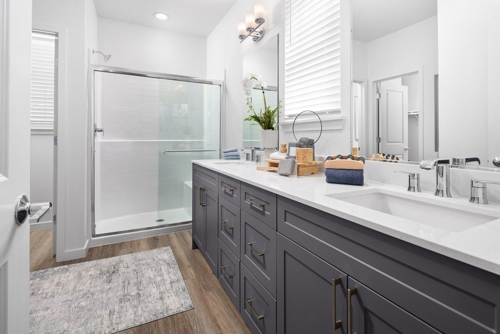 bathroom with grey cabinets and walk in shower