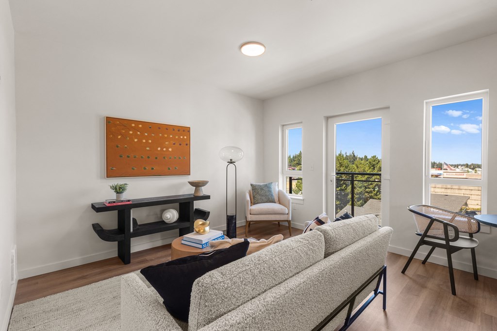 A living room with a grey couch and a painting on the wall at Two 10 by Vintage, Washington 98133