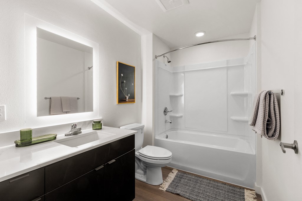 A white bathroom with a toilet, sink, and bathtub at Two 10 by Vintage, Shoreline, Washington