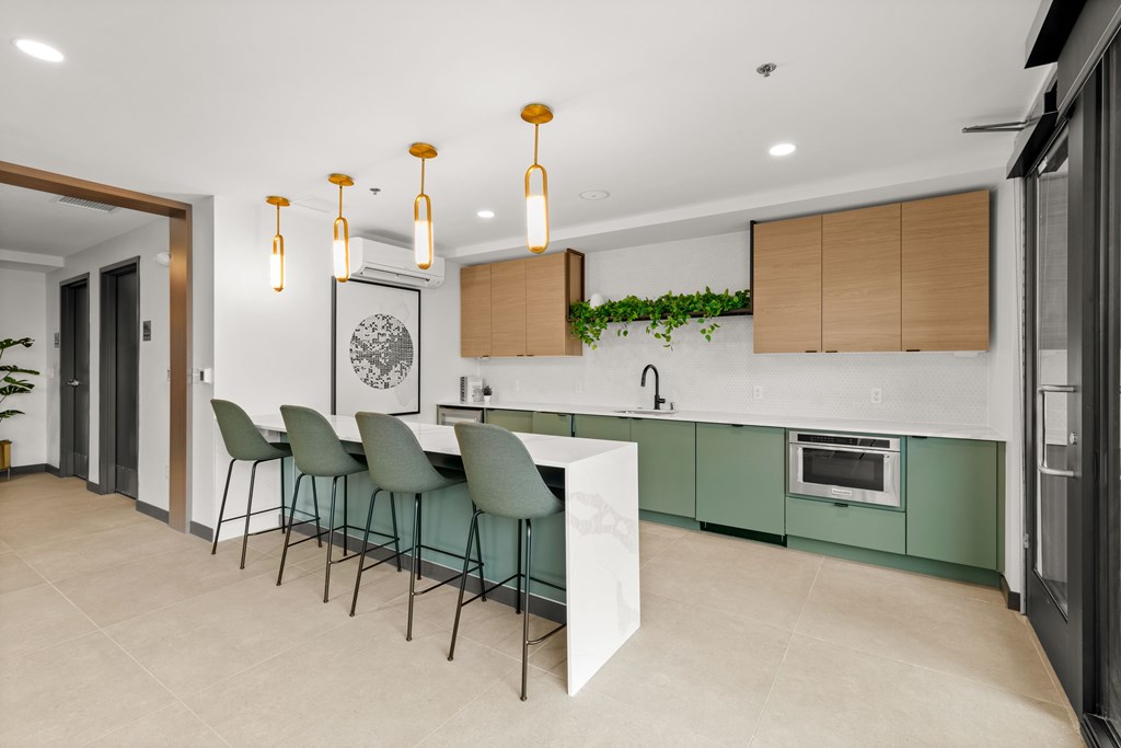 A modern kitchen with green cabinets and a white island at Two 10 by Vintage, Shoreline, WA