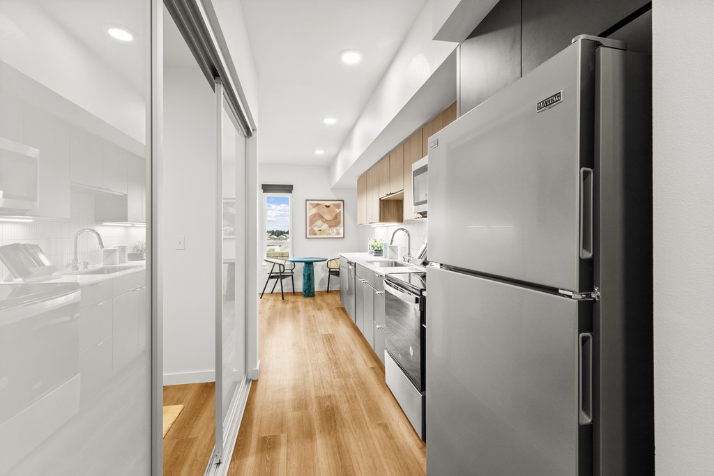 A modern kitchen with a refrigerator on the right at Two 10 by Vintage, Shoreline, WA 98133
