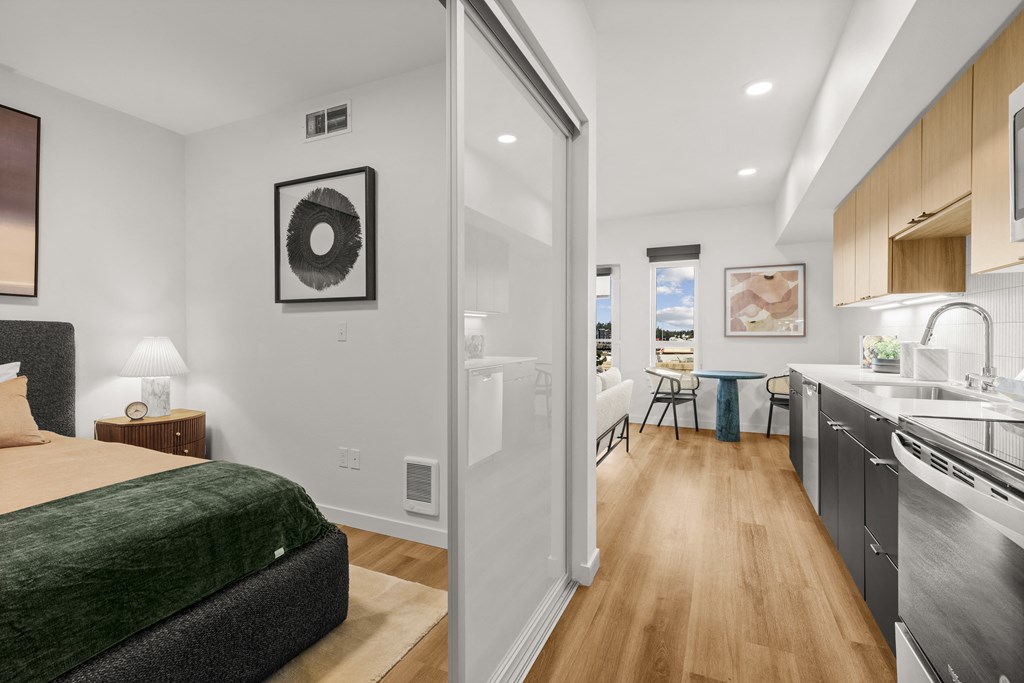 A bedroom with a bed, a nightstand with a lamp, and a picture on the wall at Two 10 by Vintage, Shoreline, Washington