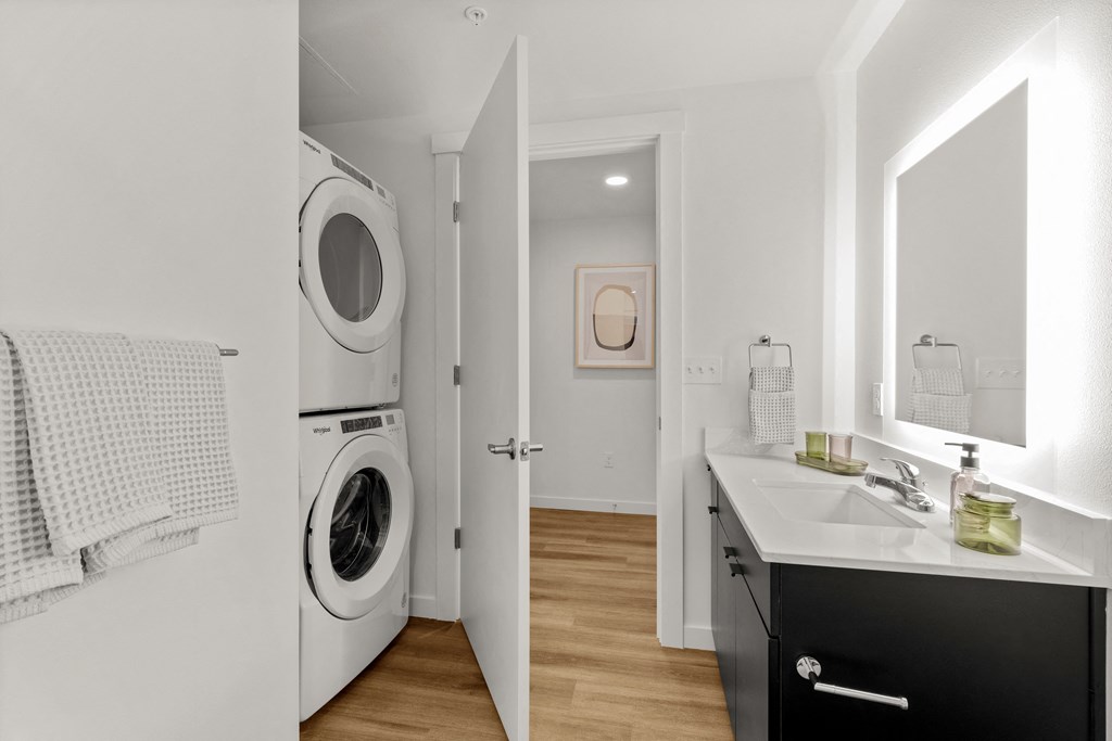 A bathroom with a washing machine built into the wall at Two 10 by Vintage, Shoreline, WA 98133