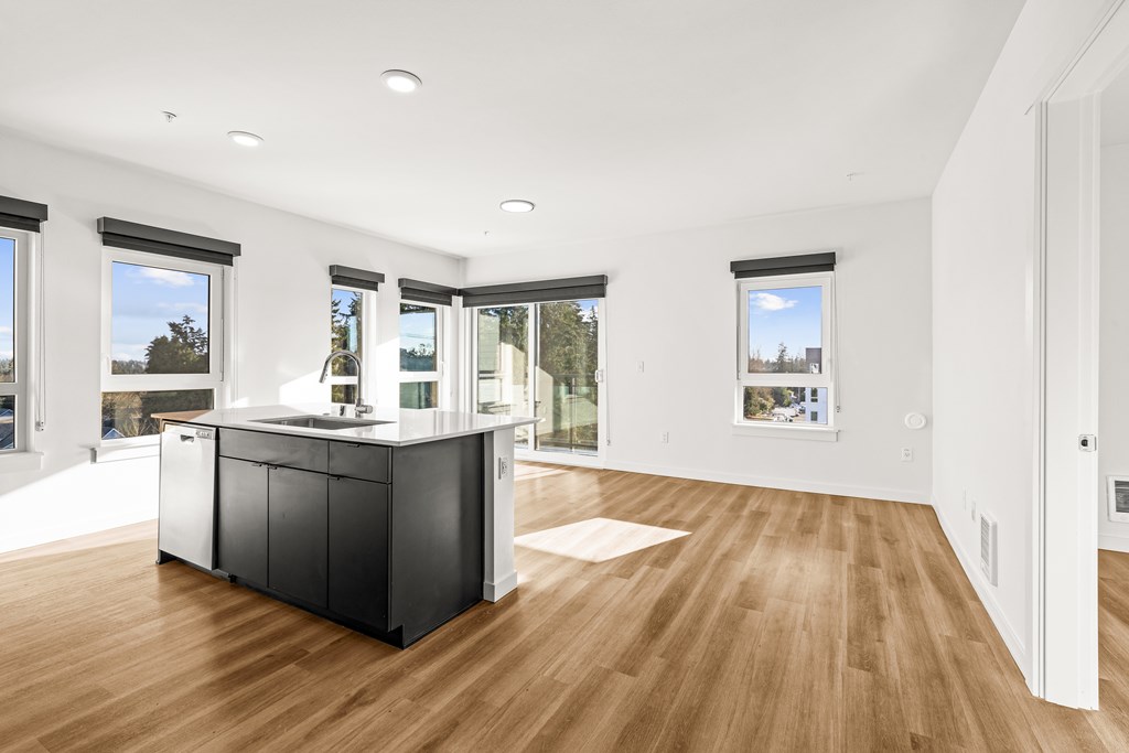 A kitchen with a black countertop and wooden flooring at Two 10 by Vintage, Shoreline, WA
