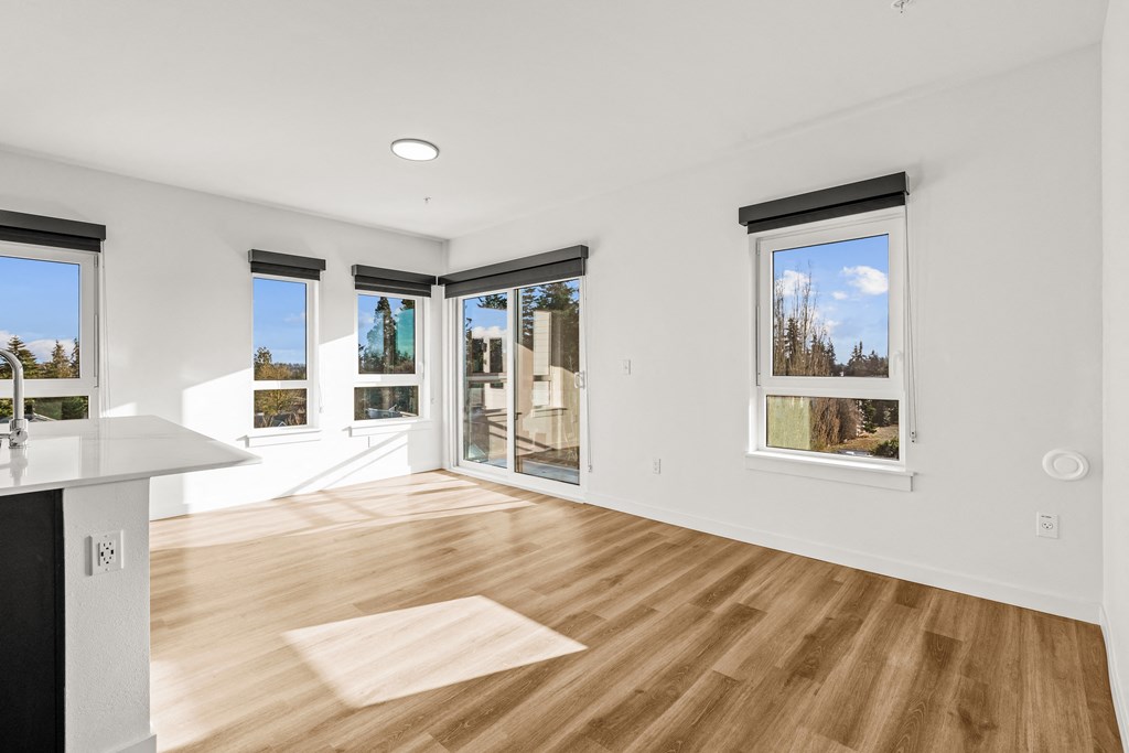 A room with a white wall and a window with a view of trees at Two 10 by Vintage, Shoreline