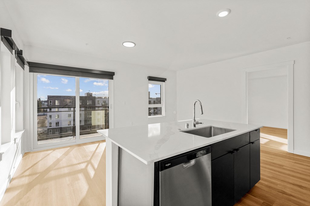 A modern kitchen with a view of the city through the windows at Two 10 by Vintage, Shoreline, 98133