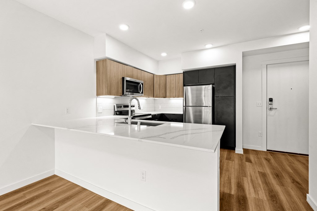 A modern kitchen with a white countertop and wooden cabinets at Two 10 by Vintage, Washington 98133