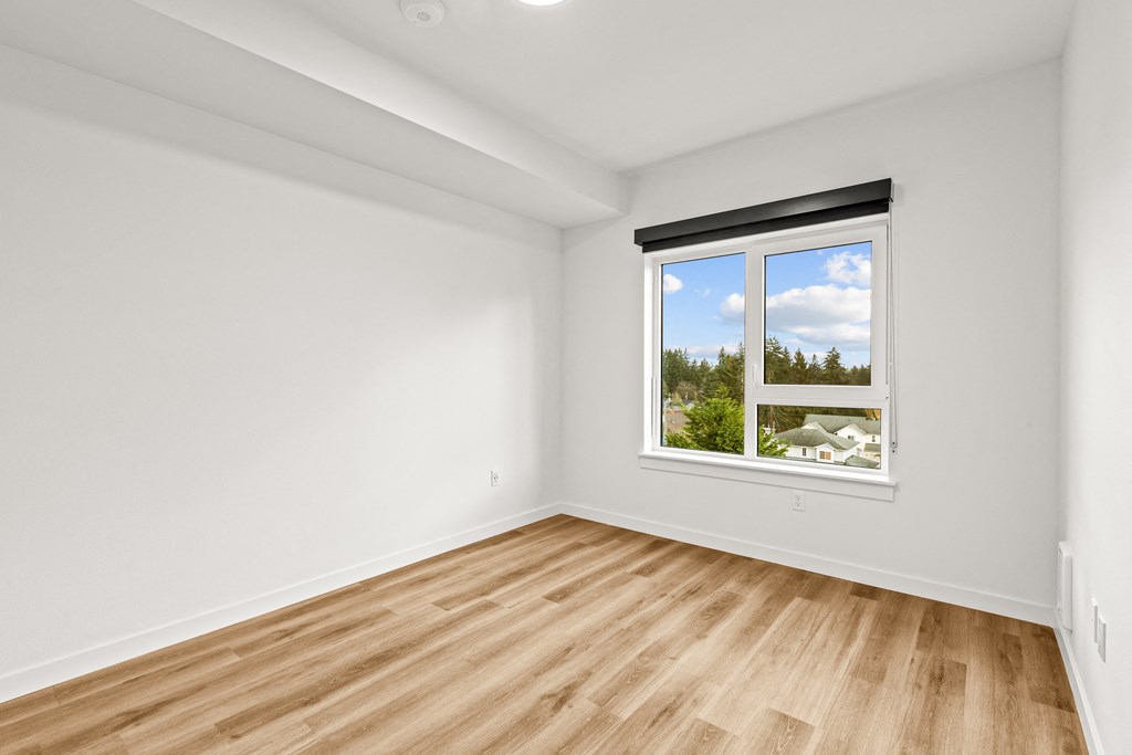 A room with a window showing a view of trees and houses outside at Two 10 by Vintage, Shoreline, WA