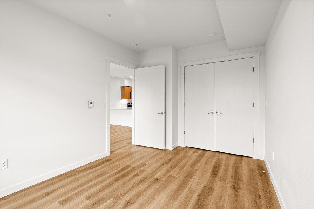 A room with white walls and wooden flooring with a white door and a white wardrobe at Two 10 by Vintage, Shoreline