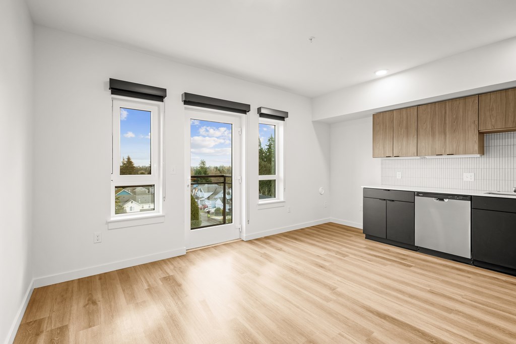 A room with wooden floors and a large window with a view of trees and a building at Two 10 by Vintage, Washington