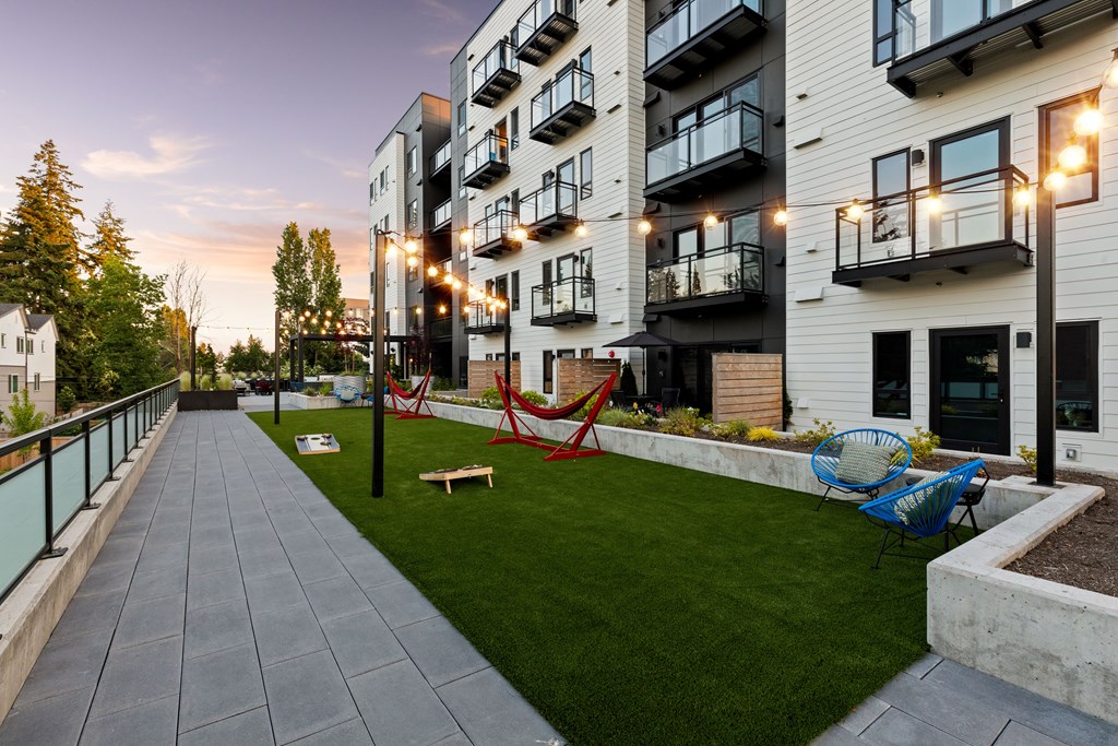 A modern apartment complex with a well-maintained outdoor area at Two 10 by Vintage, Shoreline, 98133