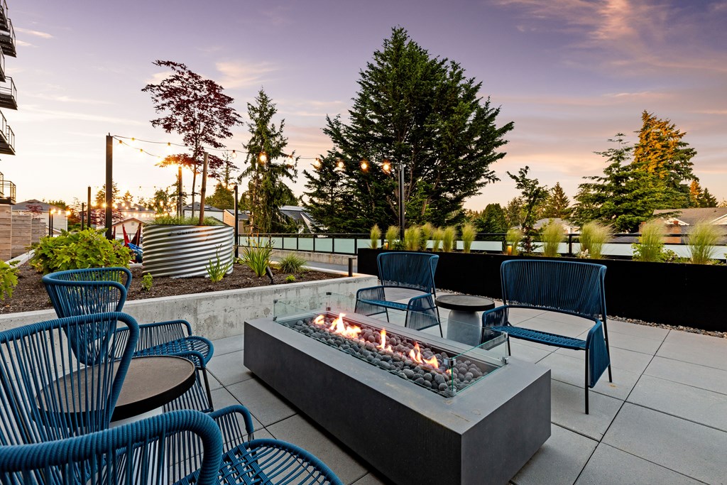 A patio with blue chairs and a fire pit  at Two 10 by Vintage, 98133