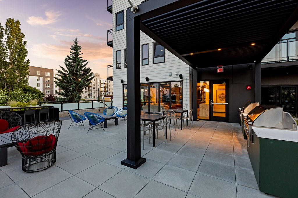 A patio with a table and chairs is in front of a building  at Two 10 by Vintage, Shoreline, WA 98133